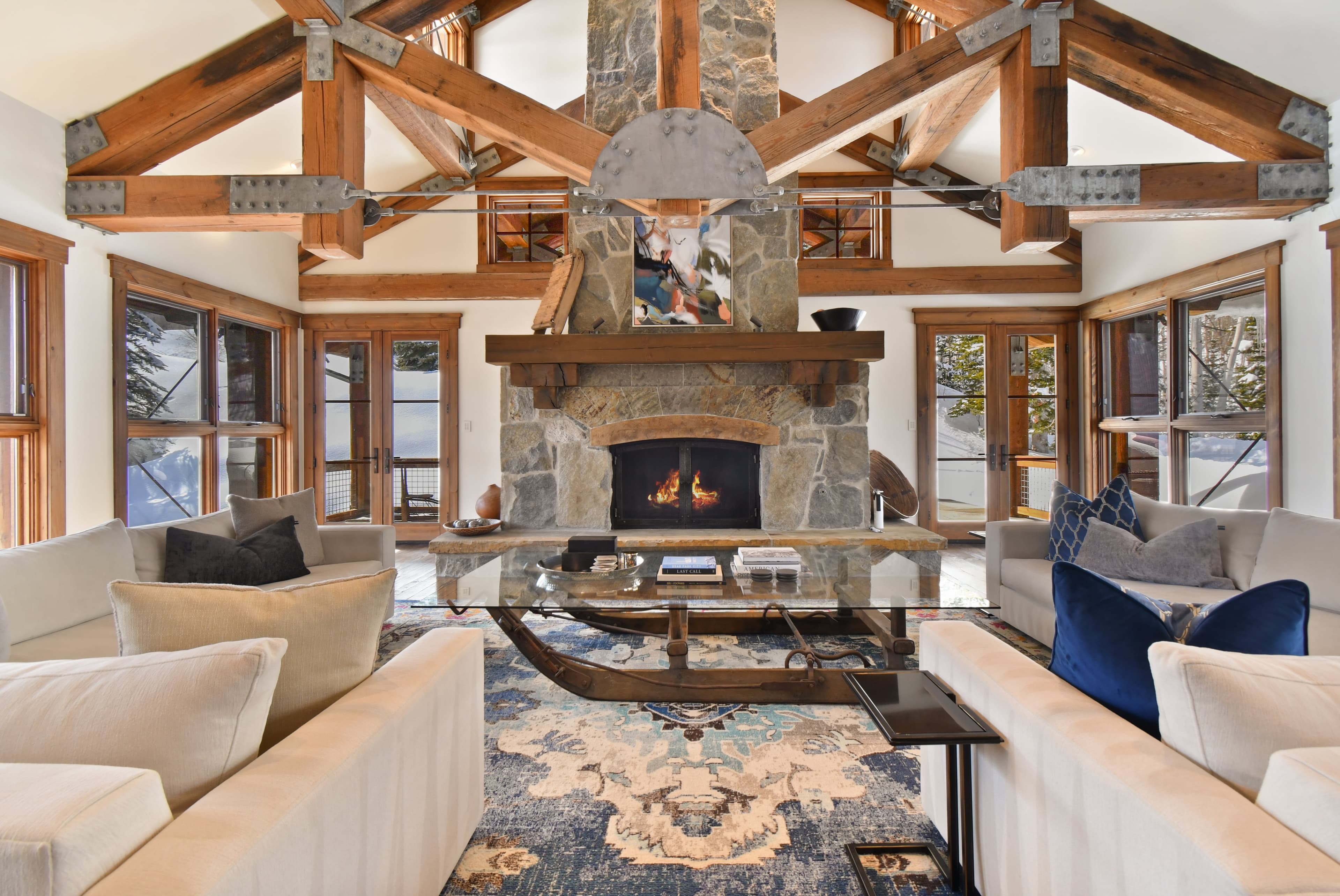 A photo centered on the lit fireplace of the main living area, and its large glass coffee table.